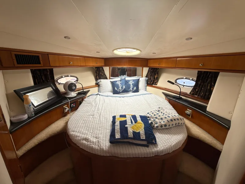 Slide: The Image of Luxurious bedroom in 2001 Carver 396 Motor Yacht with cozy bedding and elegant wood finish. - 20