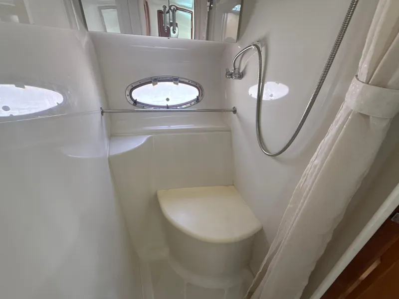 Slide: The Image of 2001 Carver 396 Motor Yacht shower area with porthole and handheld showerhead. - 22