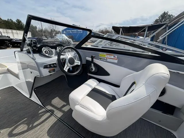 Slide: The Image of 2021 Glastron GTS 185 boat interior with steering wheel and white seating. - 18