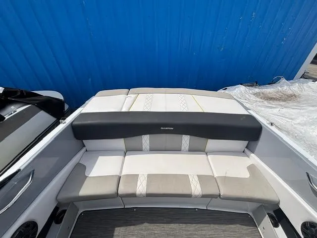 Slide: The Image of 2021 Glastron GTS 185 boat interior with cushioned seating, blue background. - 25