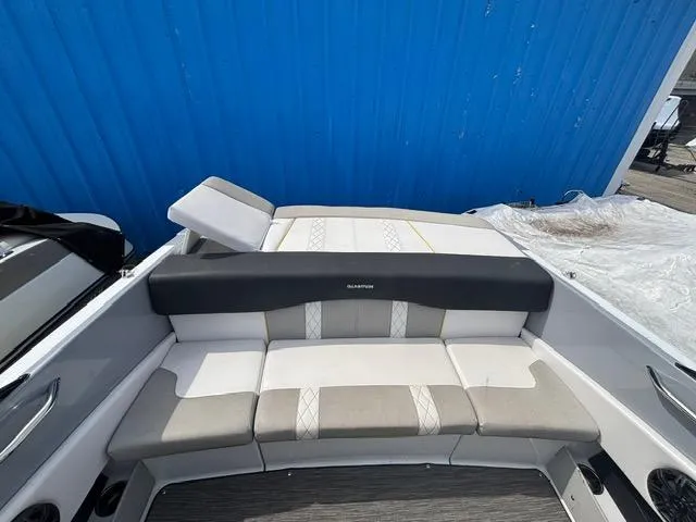 Slide: The Image of 2021 Glastron GTS 185 boat interior with cushioned seating and blue backdrop. - 26