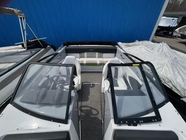 Slide: The Image of 2021 Glastron GTS 185 boat with dual windshields, parked near a blue wall. - 32