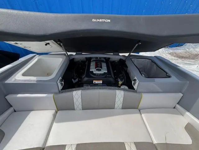 Slide: The Image of 2021 Glastron GTS 185 boat engine compartment with open hatch, showcasing interior details. - 34