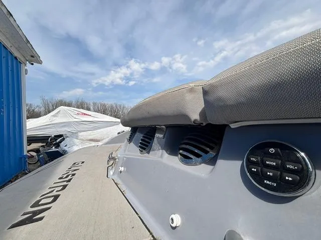 Slide: The Image of 2021 Glastron GTS 185 boat dashboard with audio controls under a clear blue sky. - 37