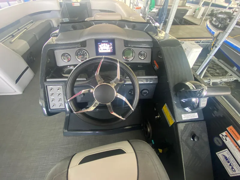 Slide: The Image of 2018 Crest Caliber 250 SLRC boat dashboard with steering wheel and control panel. - 14