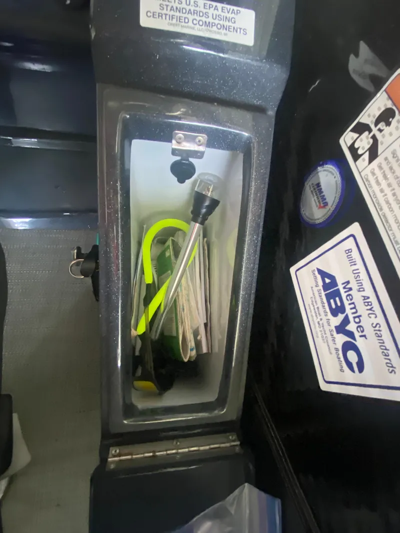 Slide: The Image of Storage compartment in a 2018 Crest Caliber 250 SLRC boat with safety equipment. - 15