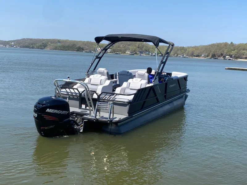 Slide: The Image of 2018 Crest Caliber 250 SLRC pontoon boat on a calm lake with Mercury outboard motor. - 37