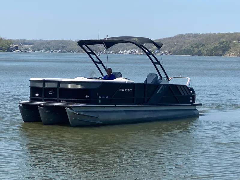 Slide: The Image of 2018 Crest Caliber 250 SLRC pontoon boat on a calm lake. - 4
