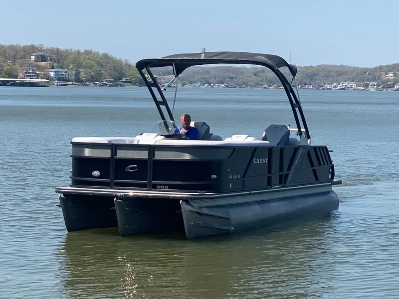 Slide: The Image of 2018 Crest Caliber 250 SLRC pontoon boat on a calm lake. - 5