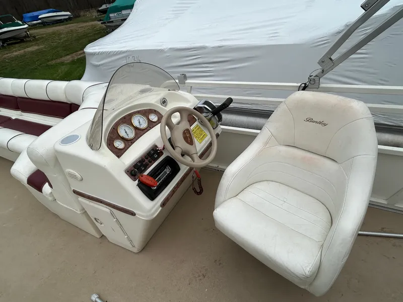 Slide: The Image of 2006 Bentley Pontoons 240 CRUISE boat interior with steering console and captain's chair. - 12
