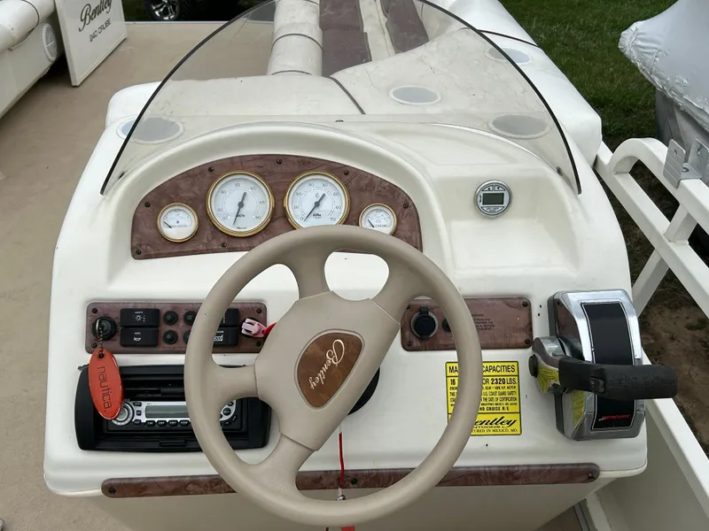 Slide: The Image of 2006 Bentley Pontoons 240 CRUISE dashboard with steering wheel and gauges. - 13