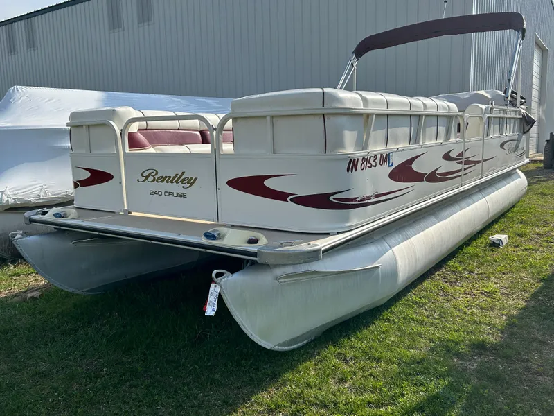 Slide: The Image of 2006 Bentley Pontoons 240 CRUISE pontoon boat with red accents, parked on grass. - 3