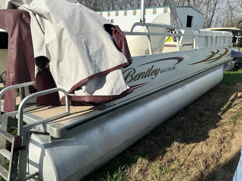 Slide: The Image of 2006 Bentley Pontoons 240 CRUISE boat, partially covered, parked on grass near a building. - 6
