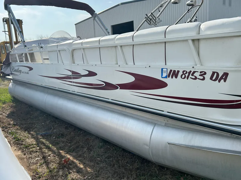 Slide: The Image of 2006 Bentley Pontoons 240 CRUISE boat with maroon graphics, docked outdoors. - 8