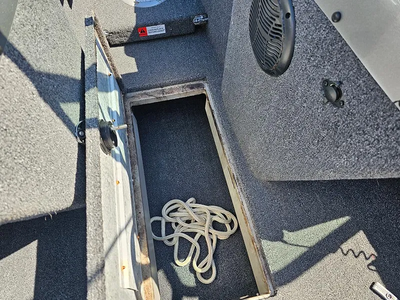 Slide: The Image of 2009 Lowe Fish & Ski FS165 boat interior with open storage compartment and rope. - 14