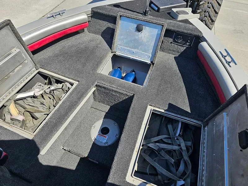 Slide: The Image of 2009 Lowe Fish & Ski FS165 boat interior with open storage compartments and equipment. - 16