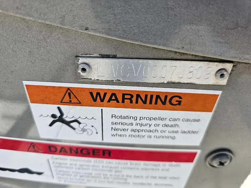 Slide: The Image of Warning labels on a 2009 Lowe Fish & Ski FS165 boat, highlighting propeller safety. - 22