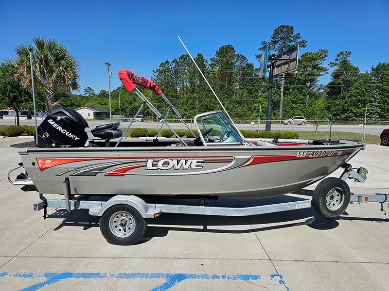 Slide: The Image of 2009 Lowe Fish & Ski FS165 boat on trailer, featuring Mercury engine, parked outdoors. - 5
