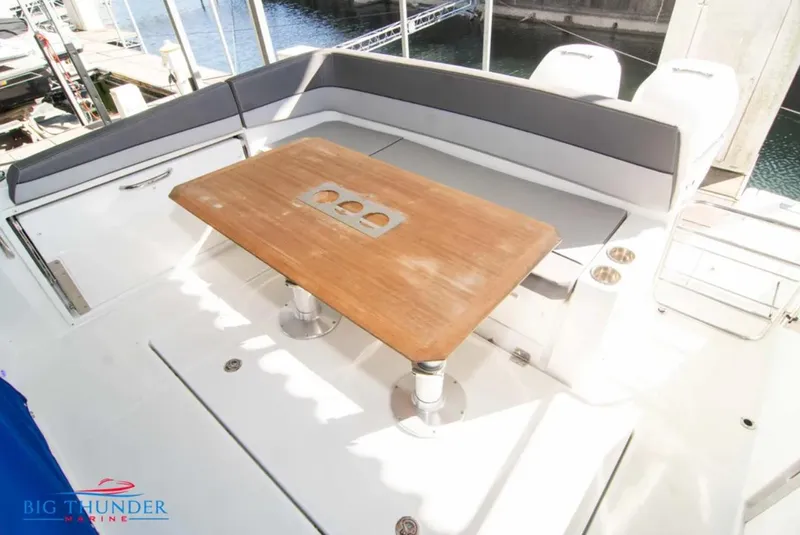 Slide: The Image of 2020 Jeanneau Leader 10.5 boat deck with wooden table and seating area. - 11