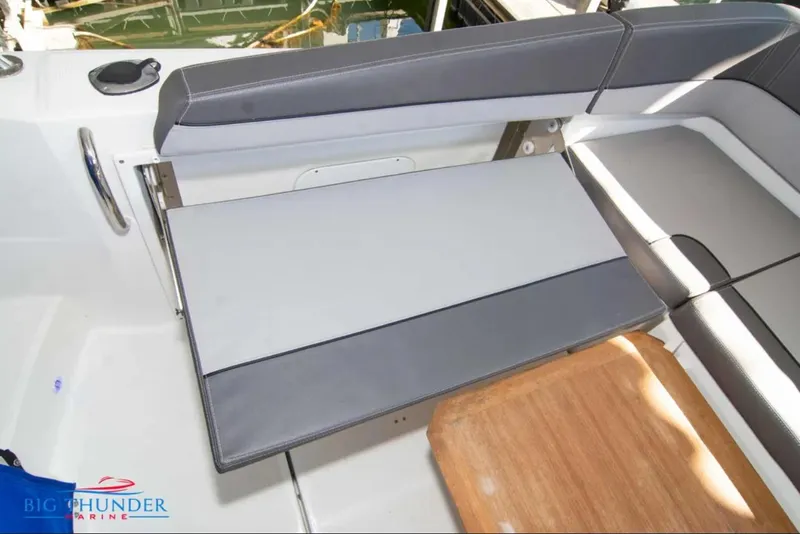 Slide: The Image of 2020 Jeanneau Leader 10.5 boat interior with gray seating and wooden table. - 14