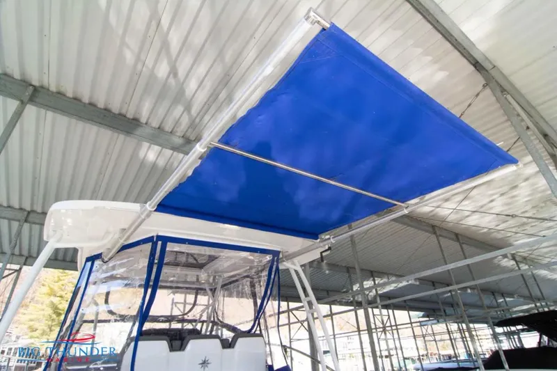 Slide: The Image of 2020 Jeanneau Leader 10.5 with blue canopy under covered dock. - 21