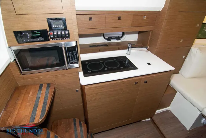 Slide: The Image of Modern kitchen in 2020 Jeanneau Leader 10.5 boat with stove, microwave, and wood cabinetry. - 29