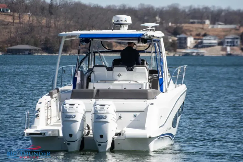 Slide: The Image of 2020 Jeanneau Leader 10.5 boat on a lake, featuring twin outboard engines. - 5