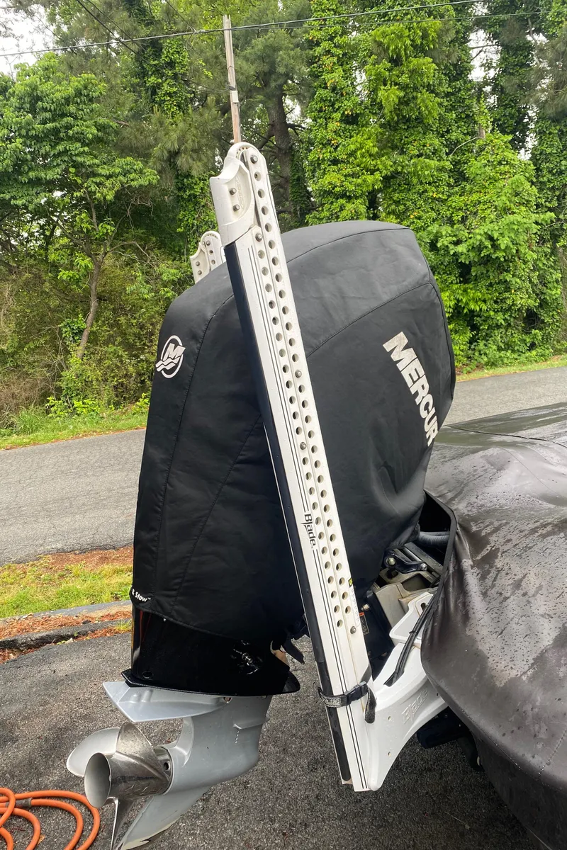 Slide: The Image of 2020 Bass Cat Eyra boat with Mercury engine, parked outdoors, surrounded by greenery. - 10