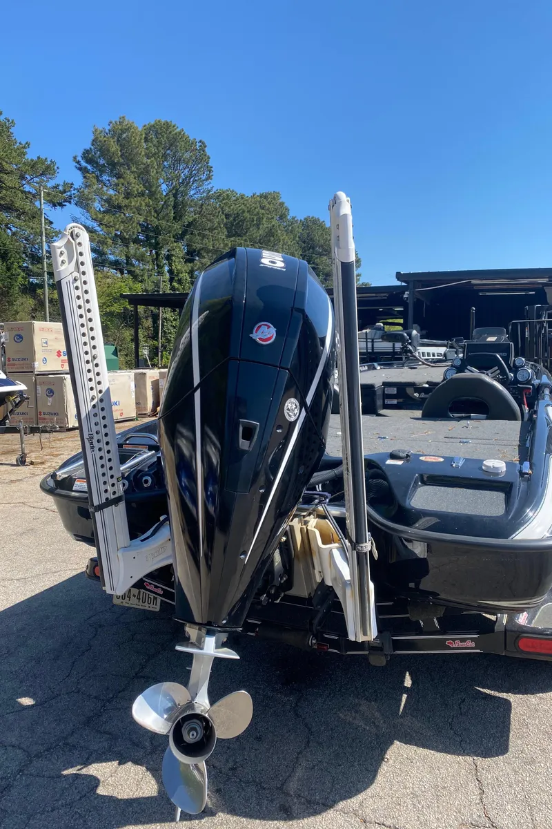 Slide: The Image of 2020 Bass Cat Eyra boat with powerful outboard motor, parked outdoors on a sunny day. - 2