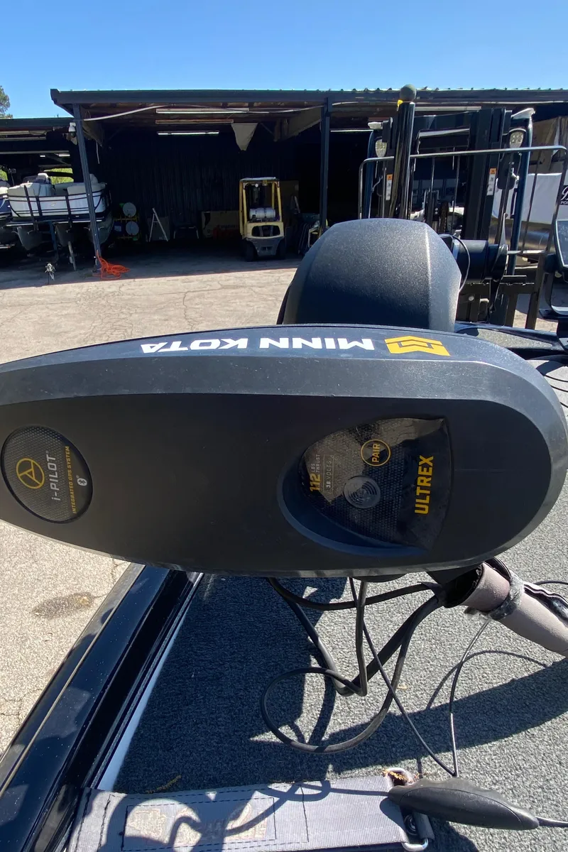 Slide: The Image of 2020 Bass Cat Eyra with Minn Kota Ultrex trolling motor in a sunny outdoor setting. - 3