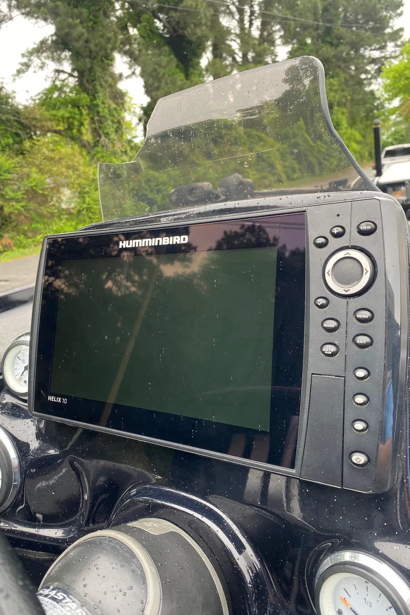 Slide: The Image of Humminbird fish finder on 2020 Bass Cat Eyra boat dashboard, surrounded by lush greenery. - 5