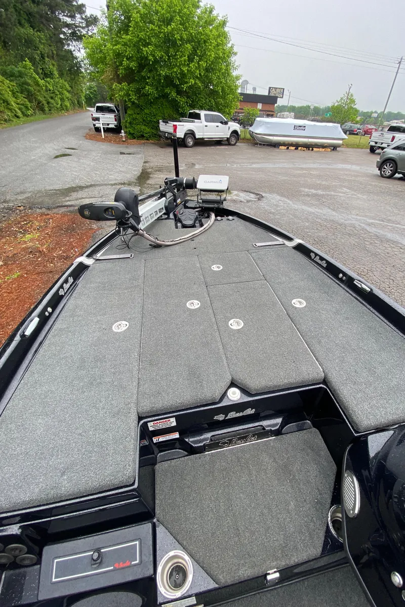 Slide: The Image of 2020 Bass Cat Eyra boat with spacious deck, parked in a lot with vehicles. - 7