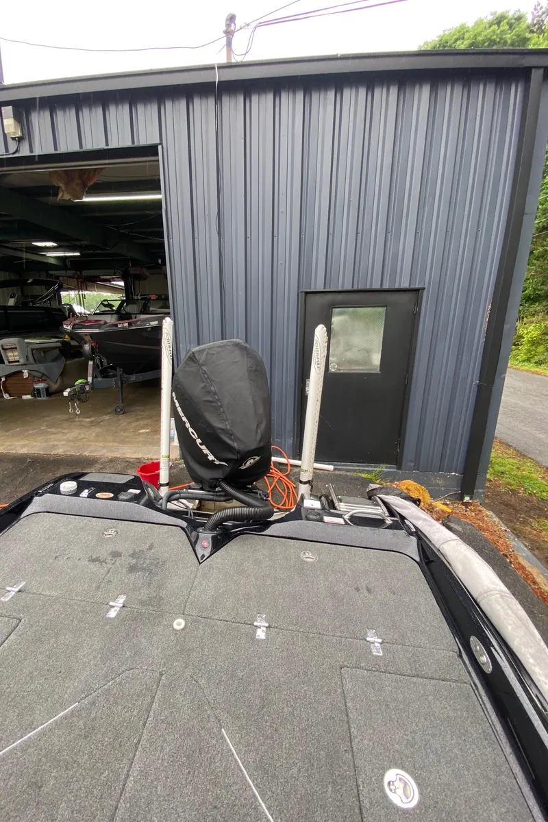 Slide: The Image of 2020 Bass Cat Eyra boat parked outside a metal garage. - 9