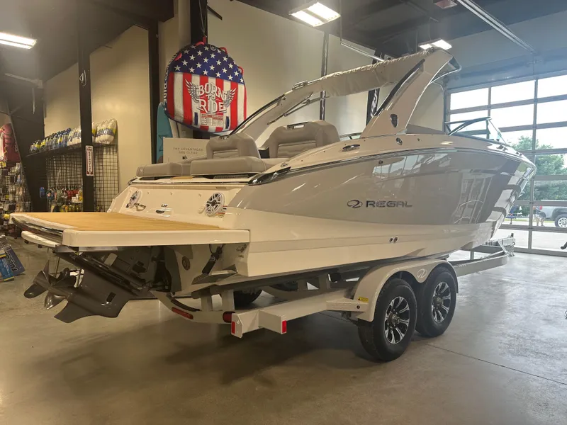 Slide: The Image of 2026 Regal LS9 boat on trailer in showroom, rear view. - 2