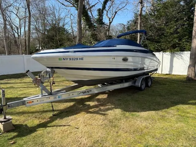 The Image of 2016 Crownline 270 SS boat on trailer, parked on grass, surrounded by trees and a white fence. - 0