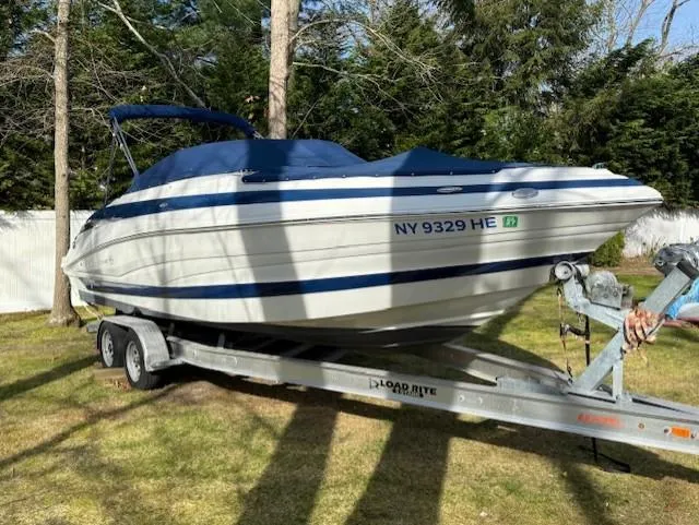 Slide: The Image of 2016 Crownline 270 SS boat on trailer, parked on grass with trees in background. - 1