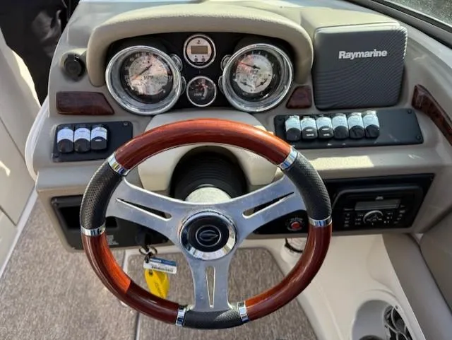 Slide: The Image of 2016 Crownline 270 SS dashboard with wood-accented steering wheel and Raymarine electronics. - 13