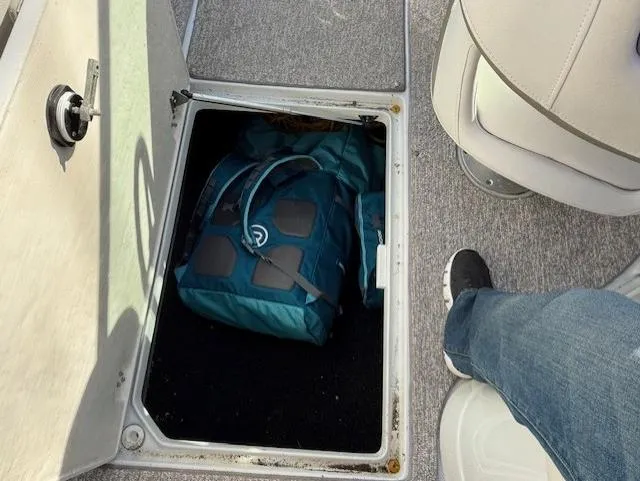 Slide: The Image of Storage compartment on 2016 Crownline 270 SS boat with a blue bag inside. - 22