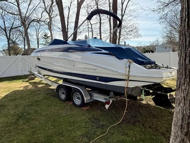 Slide: The Image of 2016 Crownline 270 SS boat on trailer in a grassy yard with trees. - 4