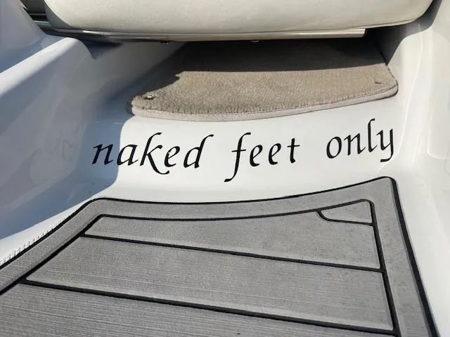 Slide: The Image of 2008 Crownline 230 LS boat interior with "naked feet only" sign on the floor mat. - 19