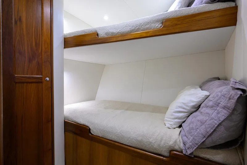 Slide: The Image of Bunk beds in 2006 Blackwell Custom Carolina yacht cabin, featuring wooden finish and cozy bedding. - 27