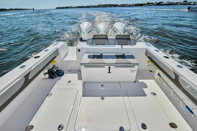 Slide: The Image of 2022 Bluewater 35 boat with triple engines cruising on open water. - 34