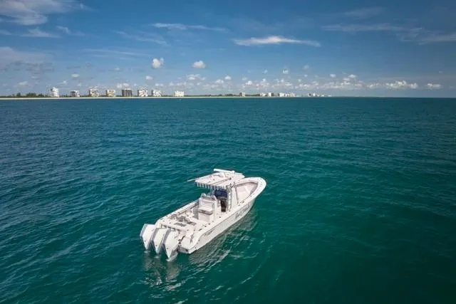 Slide: The Image of 2022 Bluewater 35 boat cruising on open ocean with city skyline in background. - 41