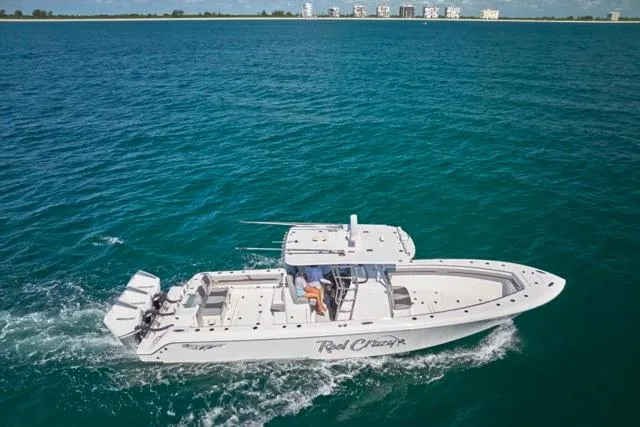 Slide: The Image of Bluewater 35 boat cruising on open water, 2022 model, with clear blue sea and distant buildings. - 46