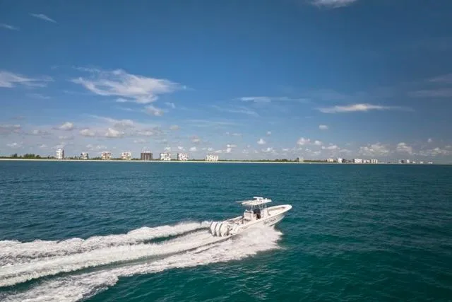 Slide: The Image of Bluewater 35 boat cruising on open sea, 2022 model, with coastal skyline in background. - 50