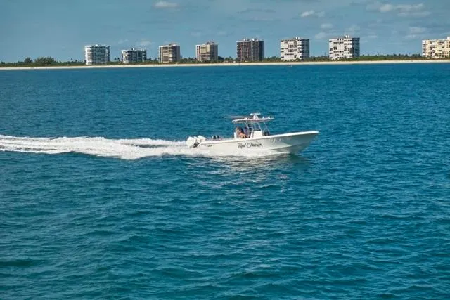 Slide: The Image of 2022 Bluewater 35 boat cruising on ocean with city skyline in background. - 58