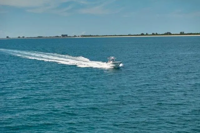 Slide: The Image of Bluewater 35 boat cruising on open sea, 2022 model, with distant shoreline. - 59