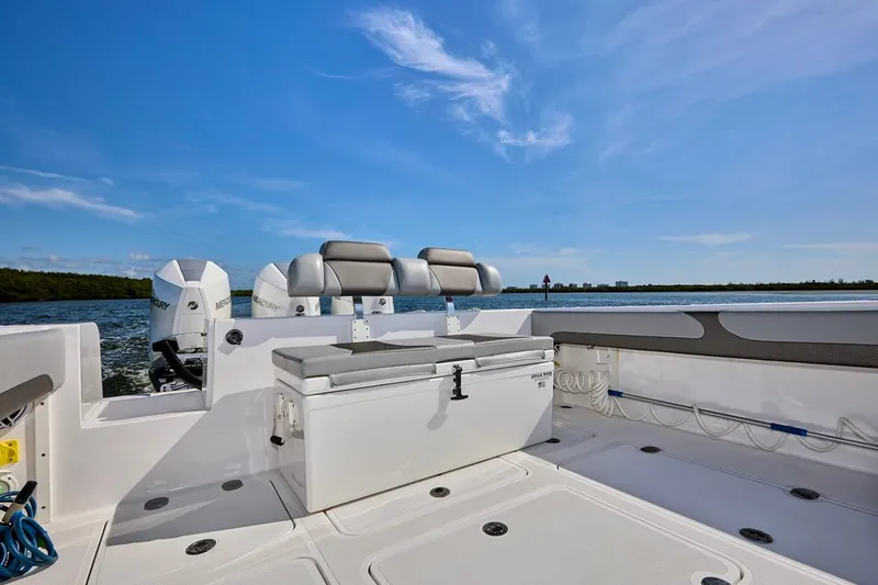 Slide: The Image of 2022 Bluewater 35 boat interior with seating and twin Mercury engines on a sunny day. - 6