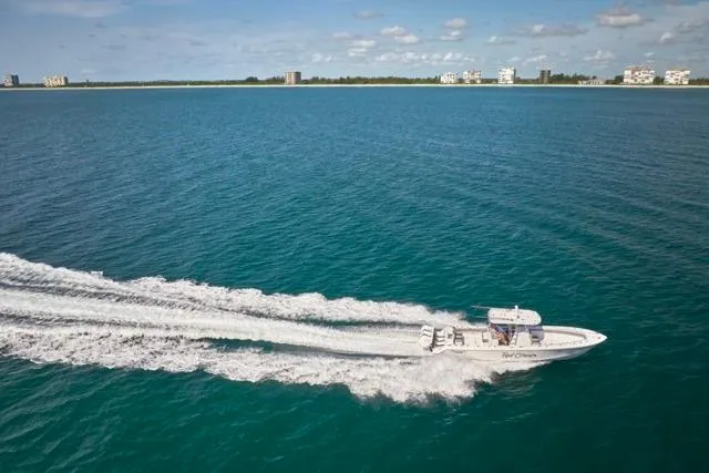 Slide: The Image of Bluewater 35 boat cruising on open water, 2022 model, with coastal buildings in the background. - 65