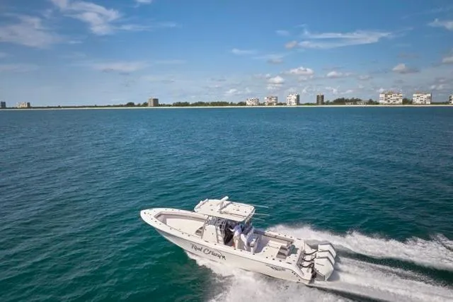 Slide: The Image of 2022 Bluewater 35 boat cruising on open water with city skyline in background. - 75